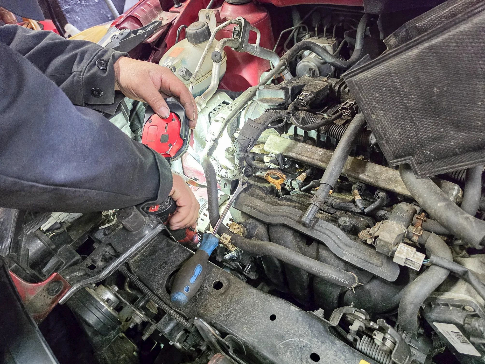 Hands and tools working on engine components
