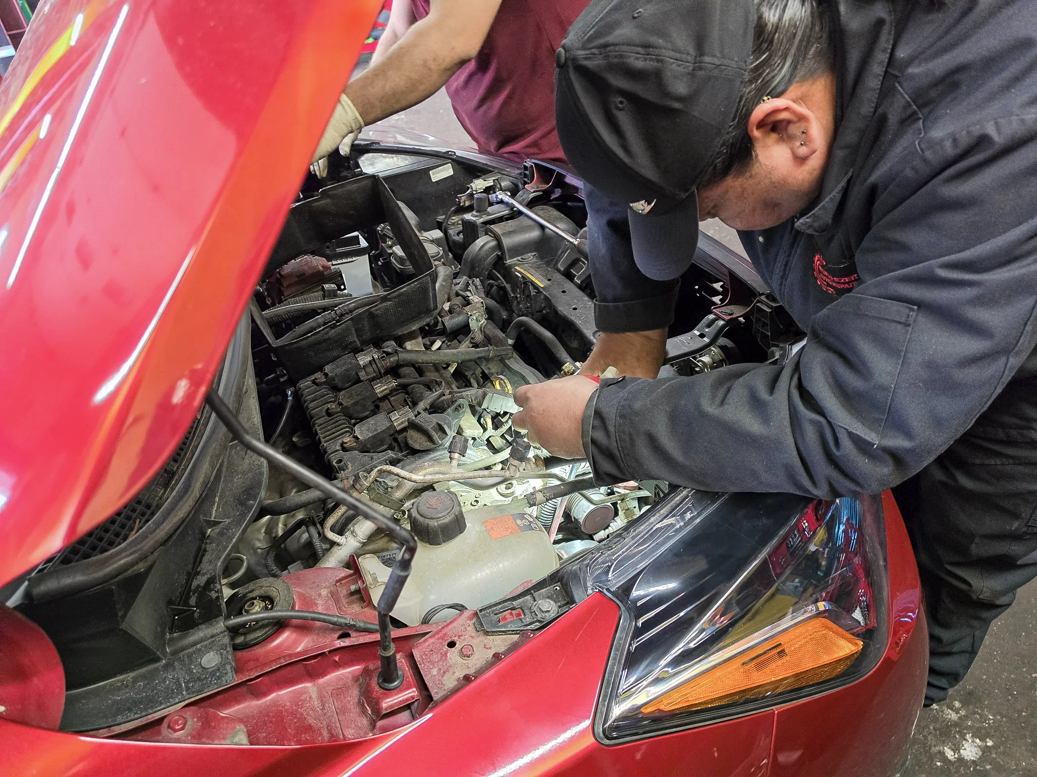 Mechanic performing routine service under the hood