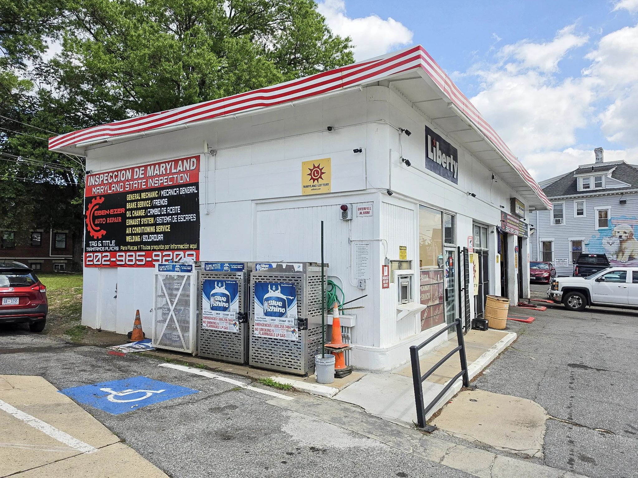 Side view of the white Liberty station and the drive leading to Ebenezer Auto Repair